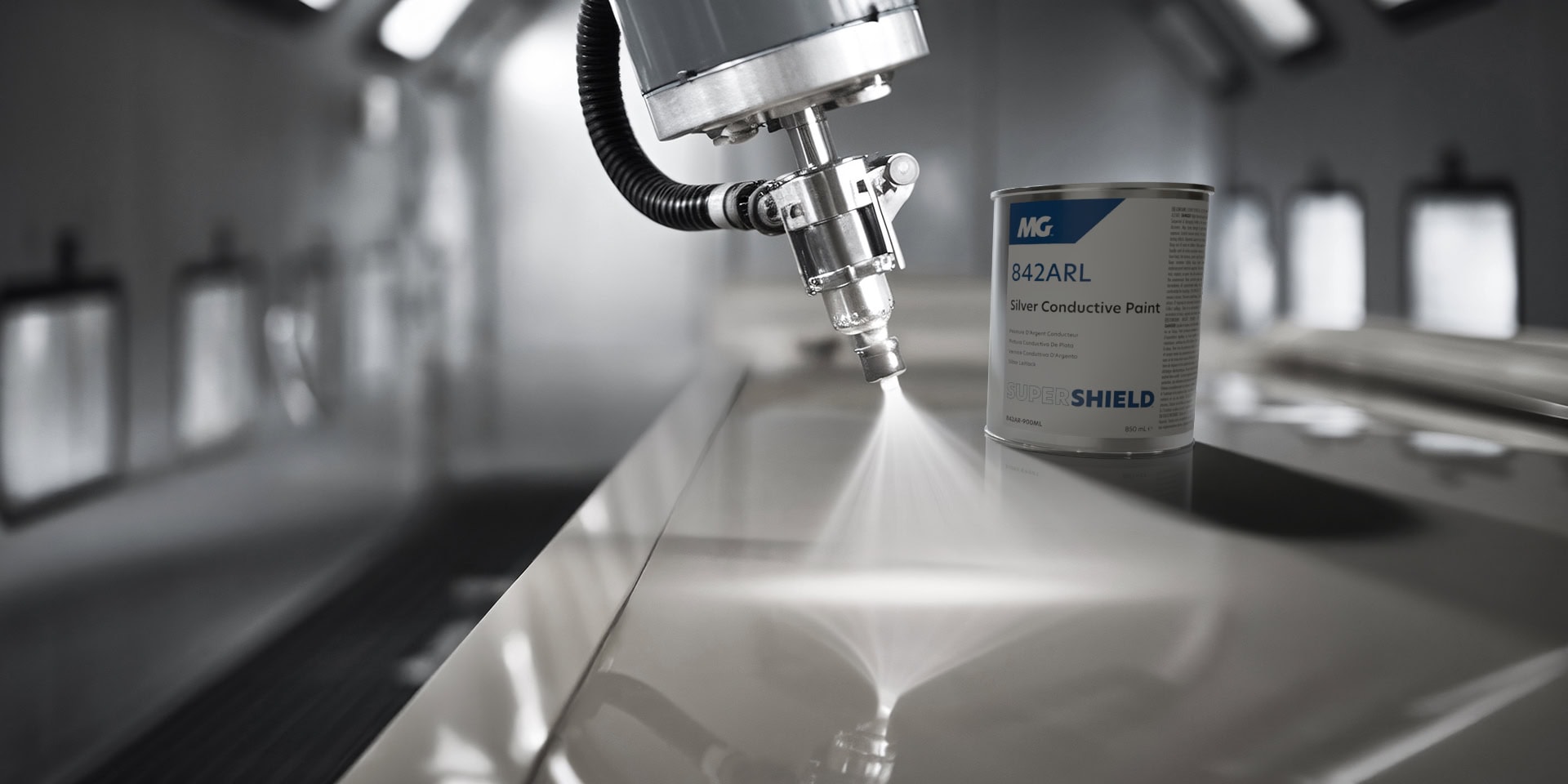 Close-up of an automated spray gun applying a smooth, even coat